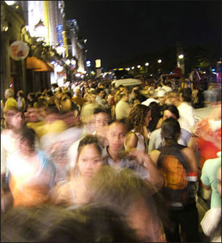 A crowd of people on the street at night. A crowd of people on the street at night.
