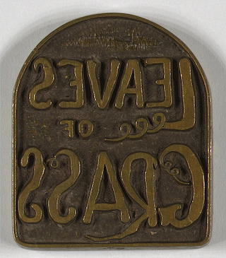 Brass plate with raised words "Leaves of Grass" as a mirror image. Brass plate with raised words "Leaves of Grass" as a mirror image.