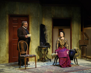 A gentleman speaks to an elegantly dressed woman seated on a chaise lounge. A gentleman speaks to an elegantly dressed woman seated on a chaise lounge.