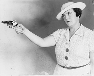 A black and white photo of a woman holding a pistol. A black and white photo of a woman holding a pistol.