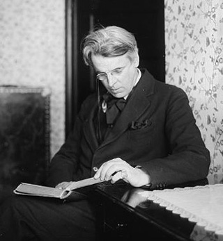 A black and white photo of William Butler Yeats reading a book. A black and white photo of William Butler Yeats reading a book.
