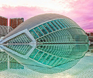 A modern structure made of glass and steel. It curves upwards into a half circle and is reflected in the pool around it. A modern structure made of glass and steel. It curves upwards into a half circle and is reflected in the pool around it.