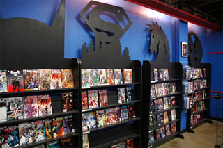 Black display shelves with a variety of comic books, each shelf adorned with a comic book symbol on top. Black display shelves with a variety of comic books, each shelf adorned with a comic book symbol on top.