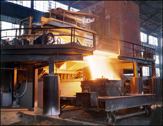 Photo inside the Brackenridge stell mill of a tilted 35-ton electric furnace pouring white-hot steel into a trough below, flying sparks indicate the fluidity of the steel. Photo inside the Brackenridge stell mill of a tilted 35-ton electric furnace pouring white-hot steel into a trough below, flying sparks indicate the fluidity of the steel.