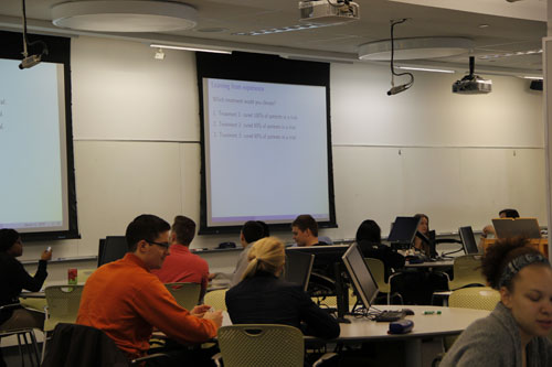 <p>We aimed to have a few concept questions in each class. For these, we showed a slide with a multiple choice question, typically related to content just discussed in a brief lecture segment. The students responded to concept questions by logging their answers via handheld clickers they brought to class.</p> <p>Participating in clicker questions was worth 5% of students grades; answers were not graded for correctness. This also served as an incentive for students to attend class.</p> A multiple-choice question is shown on a projector screen. Students use handheld clickers to submit their answers.