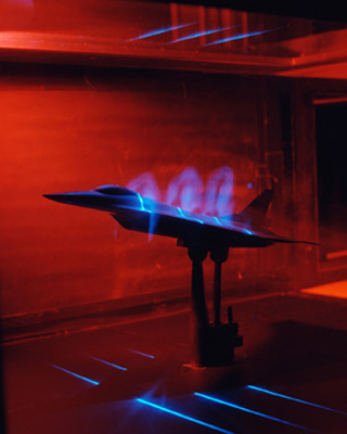 Photo of F-16 jet model in a wind tunnel test. Photo of F-16 jet model in a wind tunnel test.