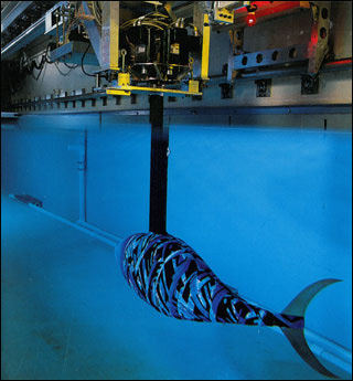 A robotic tunafish swimming in a large tank. A robotic tunafish swimming in a large tank.