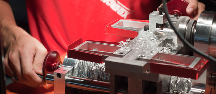 A student working a piece of metal in a lathe. A student working a piece of metal in a lathe.