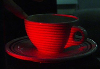 Light from a laser-illuminated coffee cup interferes with a holographic image of itself in the laboratory, producing a series of coarse interference fringes. Light from a laser-illuminated coffee cup interferes with a holographic image of itself in the laboratory, producing a series of coarse interference fringes.