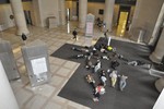 Photo of about 15 students lying on the floor of MIT’s Lobby 7, just inside a heavily-used doorway.