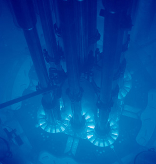 A blue glow suffuses a water-filled chamber containing pipes and other apparatus. A blue glow suffuses a water-filled chamber containing pipes and other apparatus.
