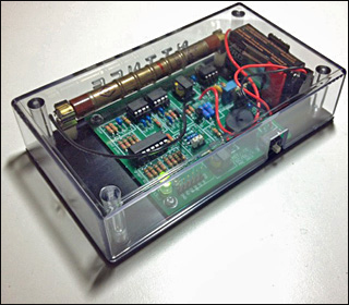 Photo of circuit board with electronics, within a clear plastic box. Photo of circuit board with electronics, within a clear plastic box.