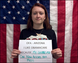 A young woman holds a sign reading "I like Obamacare Because My Grandma Can Now Afford Her Meds." A young woman holds a sign reading "I like Obamacare Because My Grandma Can Now Afford Her Meds."