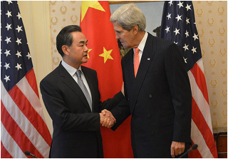 Two suited men shake hands in front of American and Chinese flags. Two suited men shake hands in front of American and Chinese flags.