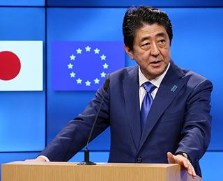 A middle-aged man, wearing a blue suit, stands at a podium. A middle-aged man, wearing a blue suit, stands at a podium.