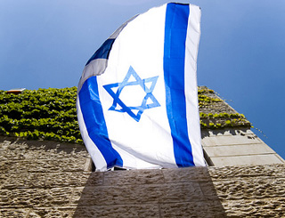 An Israeli flag flies from an open window. An Israeli flag flies from an open window.