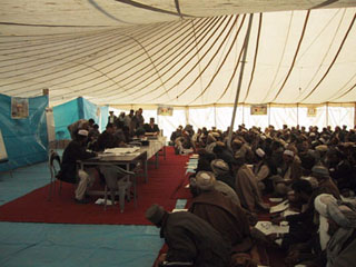 Photo of election officials and voters in a large tent. Photo of election officials and voters in a large tent.