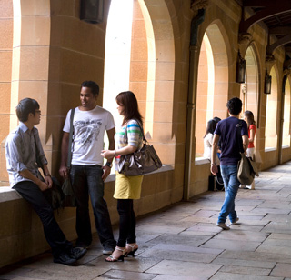 Four students having a discussion in a hallway. Four students having a discussion in a hallway.
