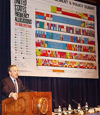 Commerce Secretary Evans presenting in front of a chart of the electromagnetic spectrum. Commerce Secretary Evans presenting in front of a chart of the electromagnetic spectrum.
