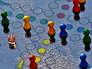 Blue and yellow board game with different colored wooden pieces and dice. Blue and yellow board game with different colored wooden pieces and dice.