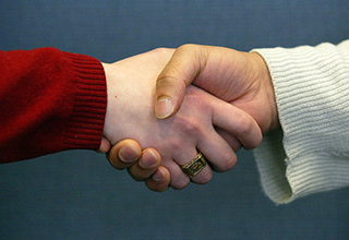 Two people shaking hands. Two people shaking hands.