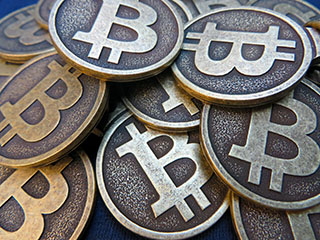A pile of Bitcoin keychains showing the logo letter "B" with two lines through it similar to a dollar sign. A pile of Bitcoin keychains showing the logo letter "B" with two lines through it similar to a dollar sign.