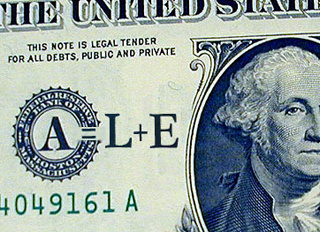 Close up of dollar bill with A equals L plus E written on it. Close up of dollar bill with A equals L plus E written on it.