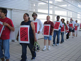A line of picketers wearing sandwich boards. A line of picketers wearing sandwich boards.