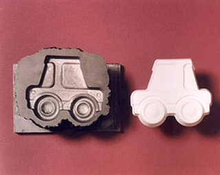 A mold of a toy car and a casting of the car. A mold of a toy car and a casting of the car.