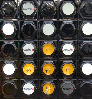A marketing display of Swatch watches in a store window. A marketing display of Swatch watches in a store window.