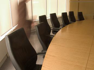 A photo of a person dashing across a typical boardroom. A photo of a person dashing across a typical boardroom.