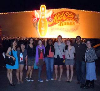 Eight students pose in front of a bowling alley. Eight students pose in front of a bowling alley.