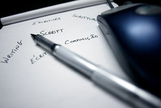 A photo of a pen lying across a writing pad. A photo of a pen lying across a writing pad.