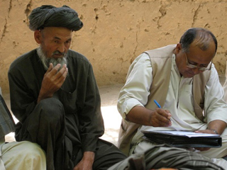 Photograph of men answering survey questions. Photograph of men answering survey questions.