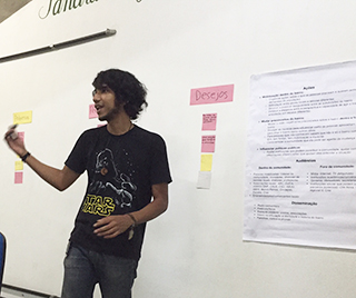 A photo of a man standing at the front of a classroom, discussing community research. A photo of a man standing at the front of a classroom, discussing community research.