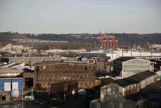 A distant photo of big buildings, warehouses, and cranes. A distant photo of big buildings, warehouses, and cranes.