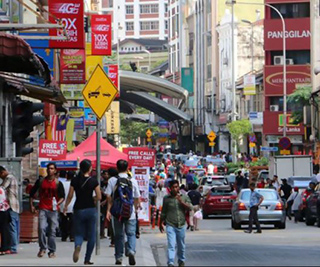 A photograph of a vibrant street scene. Shops line the sides of the road, while pedestrians walk down the middle. A photograph of a vibrant street scene. Shops line the sides of the road, while pedestrians walk down the middle.