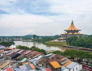 A photo of a grand building topped with gold in the background with a cluster of small shabby houses in the foreground. A photo of a grand building topped with gold in the background with a cluster of small shabby houses in the foreground.