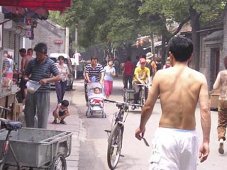 A photo of a small busy street in China. A photo of a small busy street in China.
