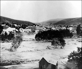 A photogrpah of a flash flood ravaging a town. A photogrpah of a flash flood ravaging a town.