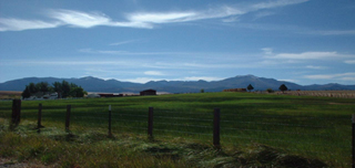 A landscape photo of farmland with mountains in the distance. A landscape photo of farmland with mountains in the distance.
