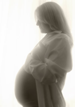 A sideview of a woman with an extended stomach. A sideview of a woman with an extended stomach.