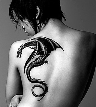 A black and white photograph of a large dragon tattoo on a woman's back. A black and white photograph of a large dragon tattoo on a woman's back.