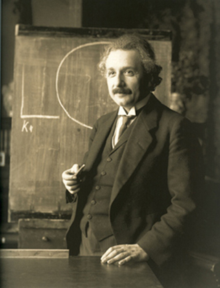 A photograph of Albert Einstein standing in front of a chalk board. A photograph of Albert Einstein standing in front of a chalk board.