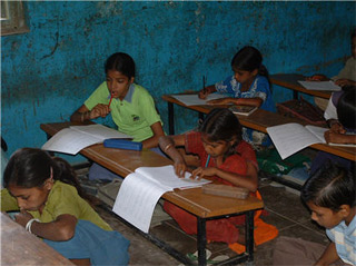Photo of school-aged children in class. Photo of school-aged children in class.