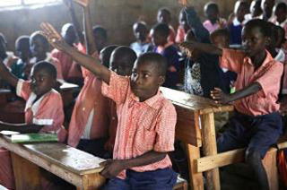 Photograph of student raising his hand. Photograph of student raising his hand.