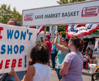 Protesters rally holding signs that read "save Market Basket" and "I won't shop here." Protesters rally holding signs that read "save Market Basket" and "I won't shop here."