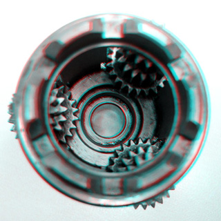 Photo of a circular metal bracket containing three sets of smaller gears. Photo of a circular metal bracket containing three sets of smaller gears.